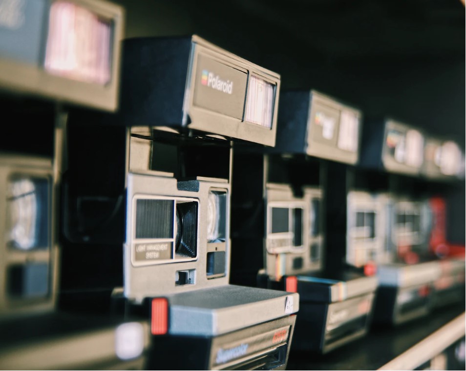 A row of 5 classic Polaroid cameras