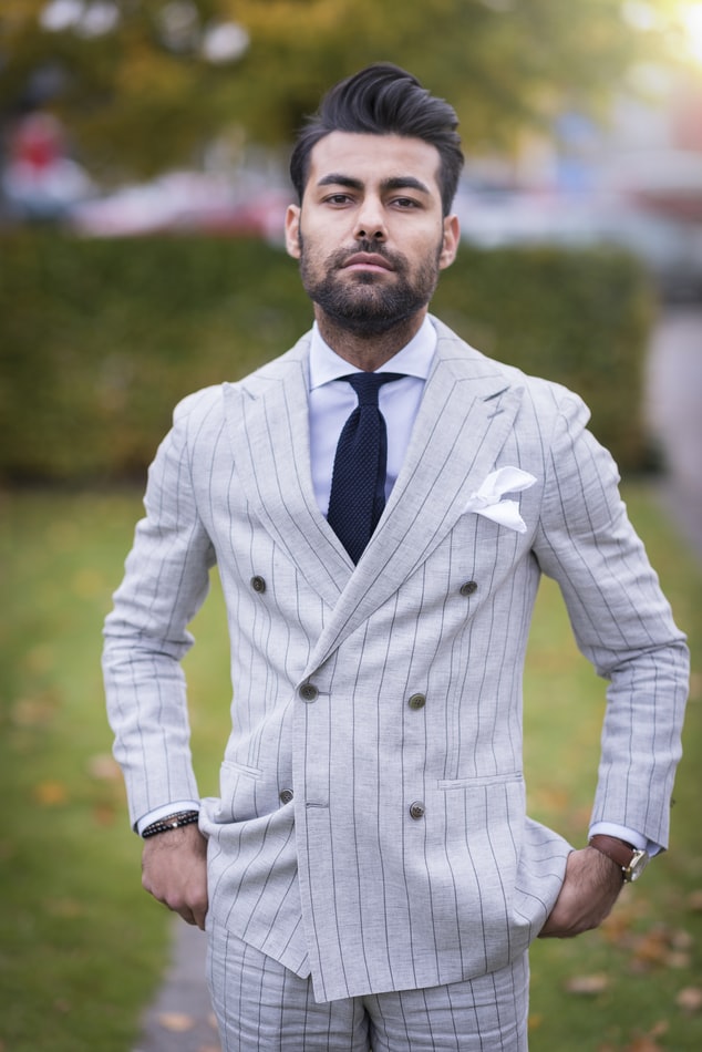 Confident man in pin-striped suite and tie looks like he has everything figured out but he still has room to grow.